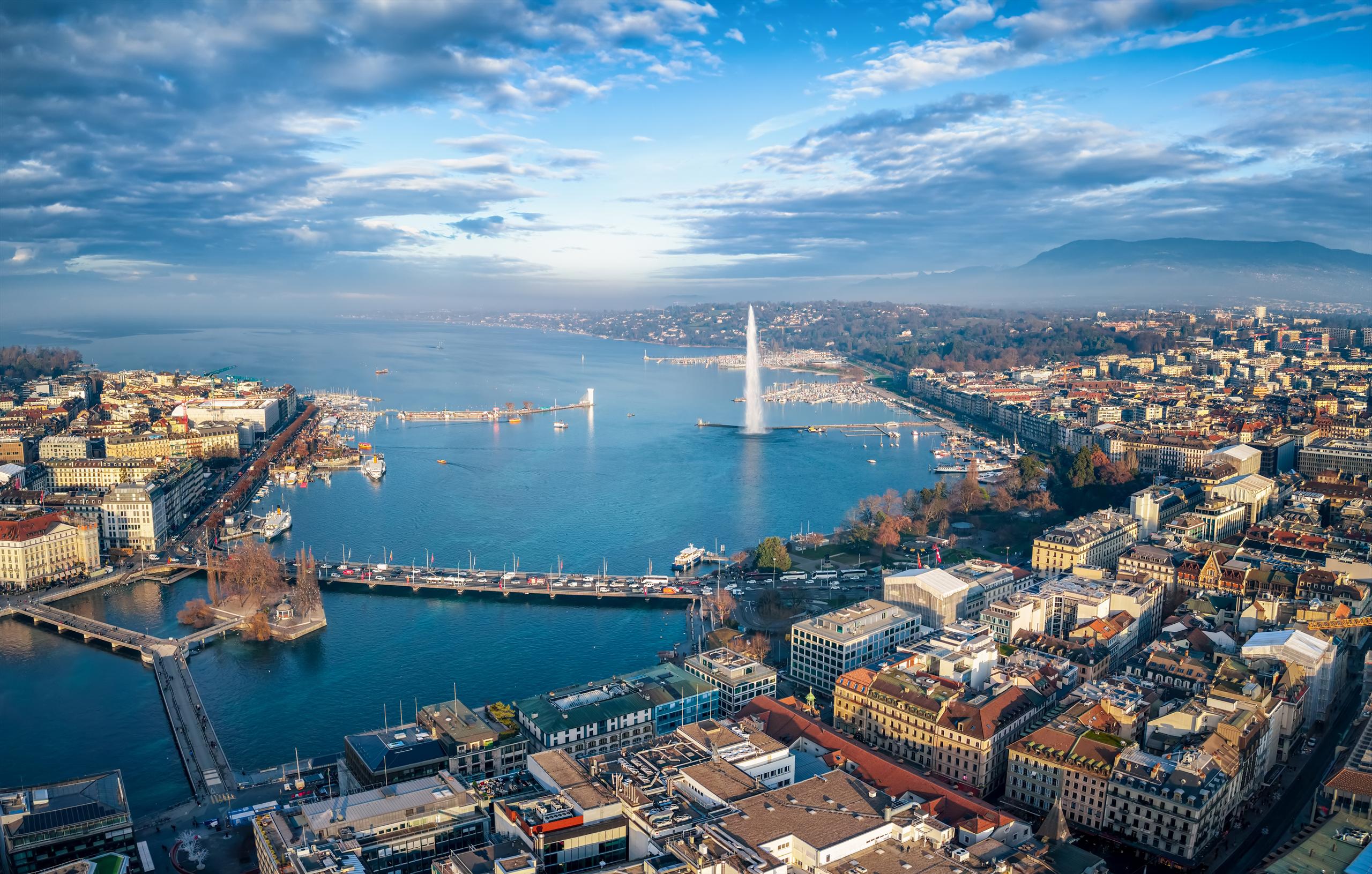 Aerial view over Geneva, the Jet d'Eau and Lake Geneva, with the Alps beyond